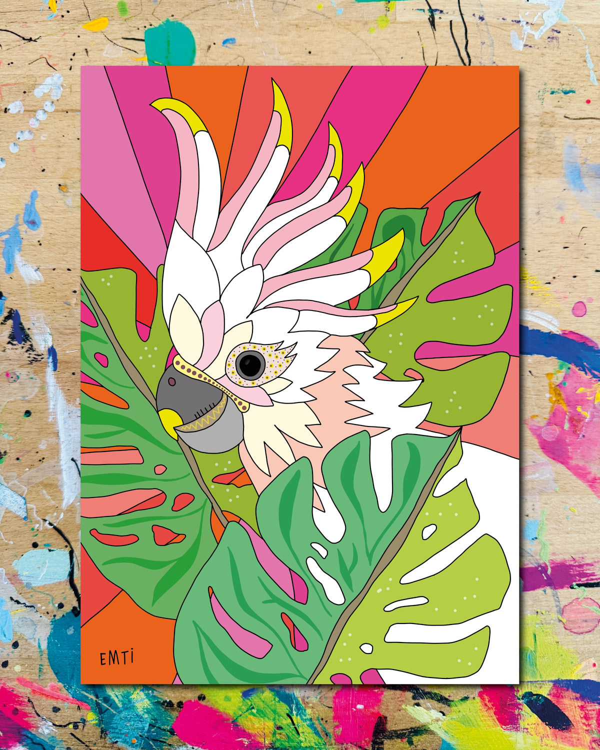Postkarte: ein weisser Kakadu zwischen Monstera-Blättern vor bunten Strahlen