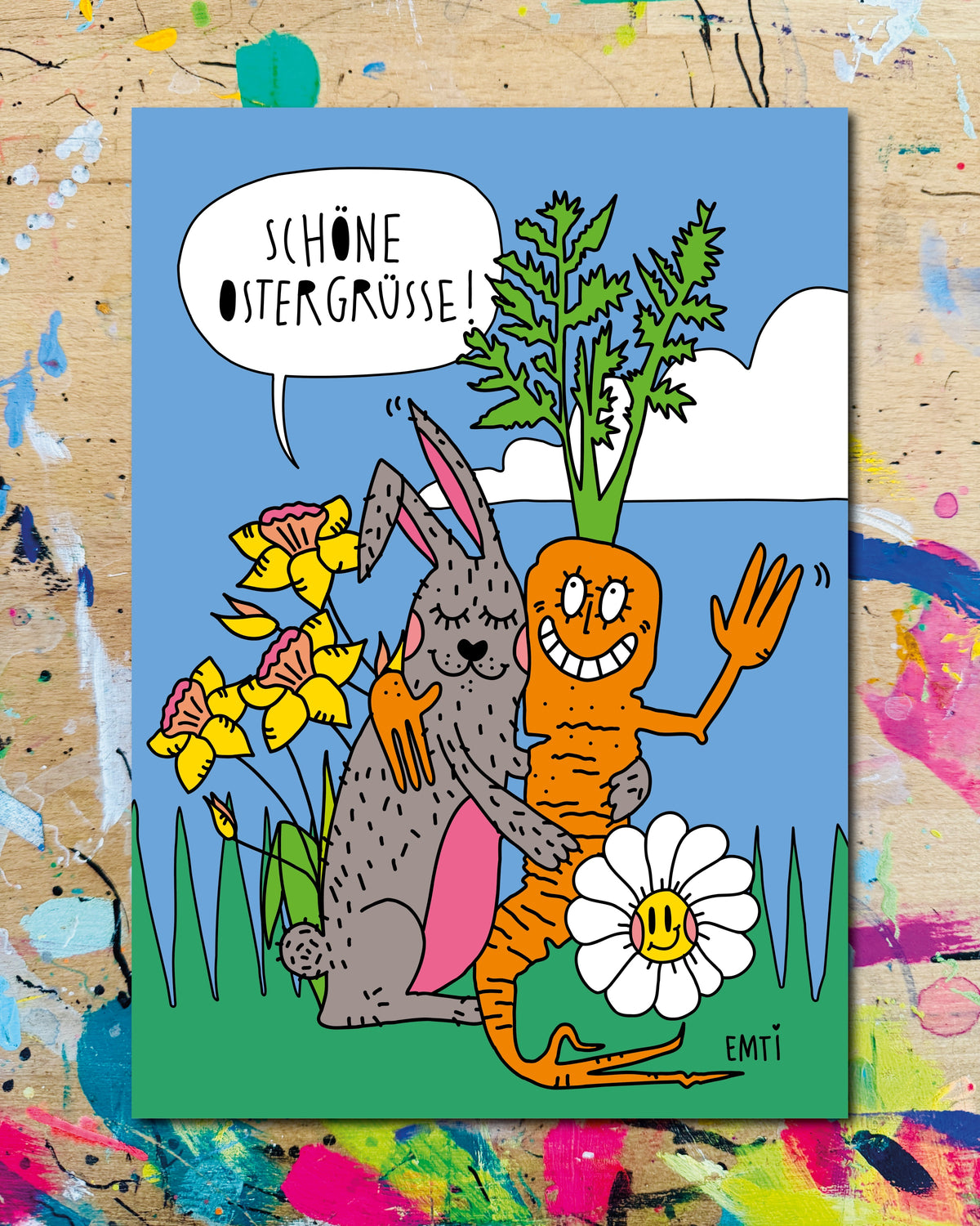 Postkarte: ein Hase umarmt eine Möhre mit Gesicht, zwischen Narzissen und einer Margerite, dazu der Schriftzug „Schöne Ostergrüße!“