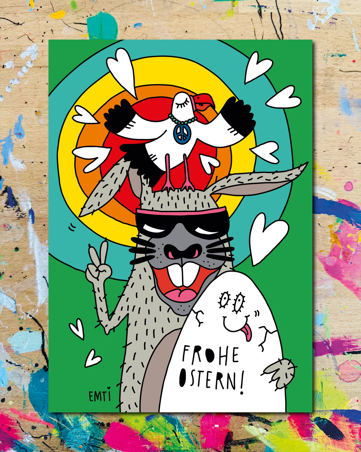 Postkarte: ein Hase mit Sonnenbrille macht ein Peace-Zeichen, auf seinem Kopf ein Vogel, daneben ein Ei mit Gesicht, dazu der Schriftzug „Frohe Ostern!“