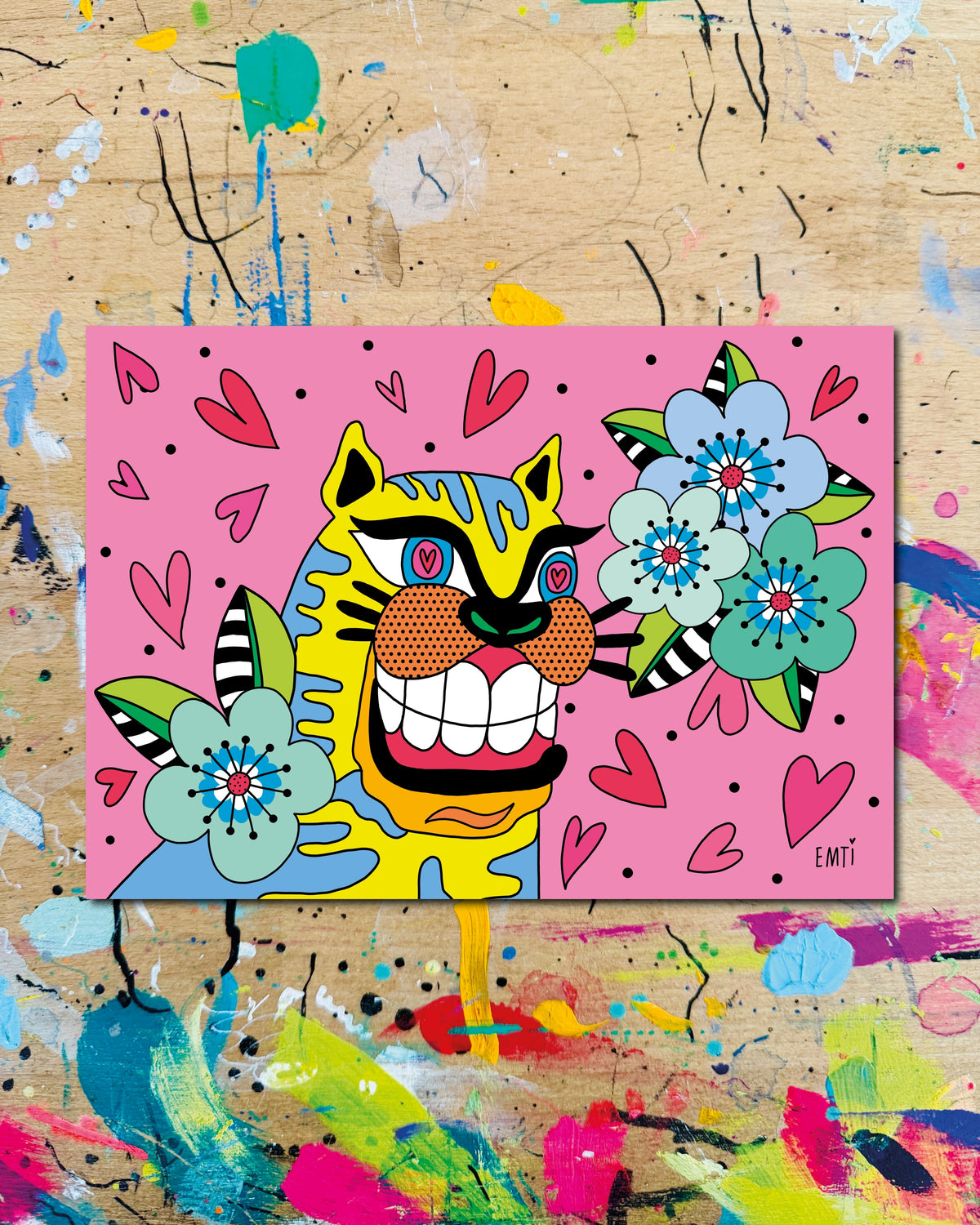 Postkarte quer: eine breit grinsende gestreifte Katze zwischen blauen Blüten und Herzen auf rosa Grund