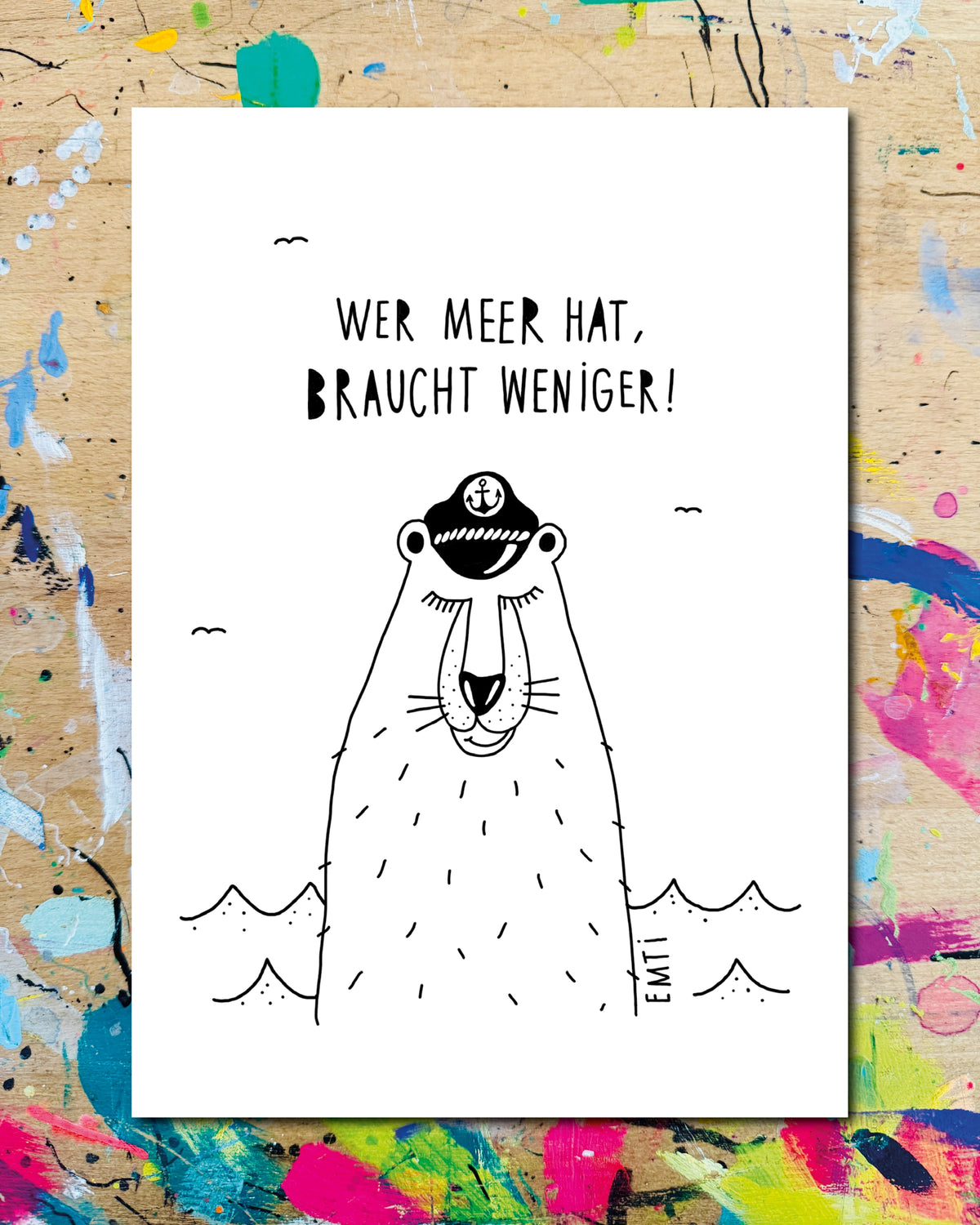 Postkarte: ein Bär mit Kapitänsmütze im Meer, dazu der Schriftzug „Wer Meer hat, braucht weniger!“