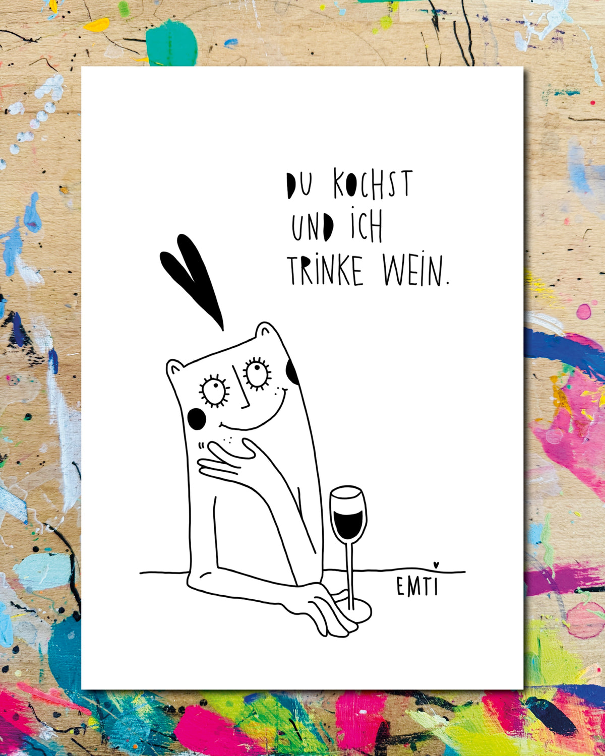 Postkarte: eine Figur lehnt mit einem Weinglas am Tisch, darüber ein Herz, dazu der Schriftzug „Du kochst und ich trinke Wein.“