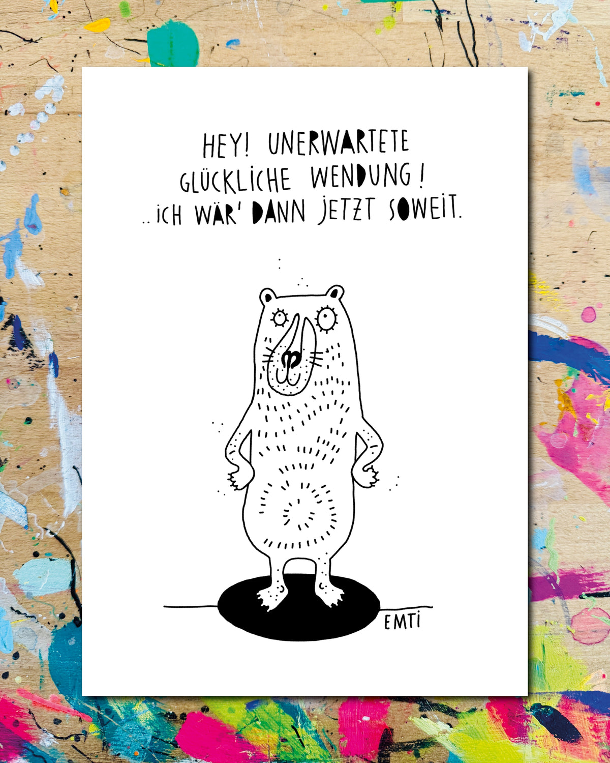 Postkarte: ein Bär mit den Pfoten in den Hüften steht auf einem schwarzen Fleck, dazu der Schriftzug „Hey! Unerwartete glückliche Wendung! … ich wär' dann jetzt soweit.“