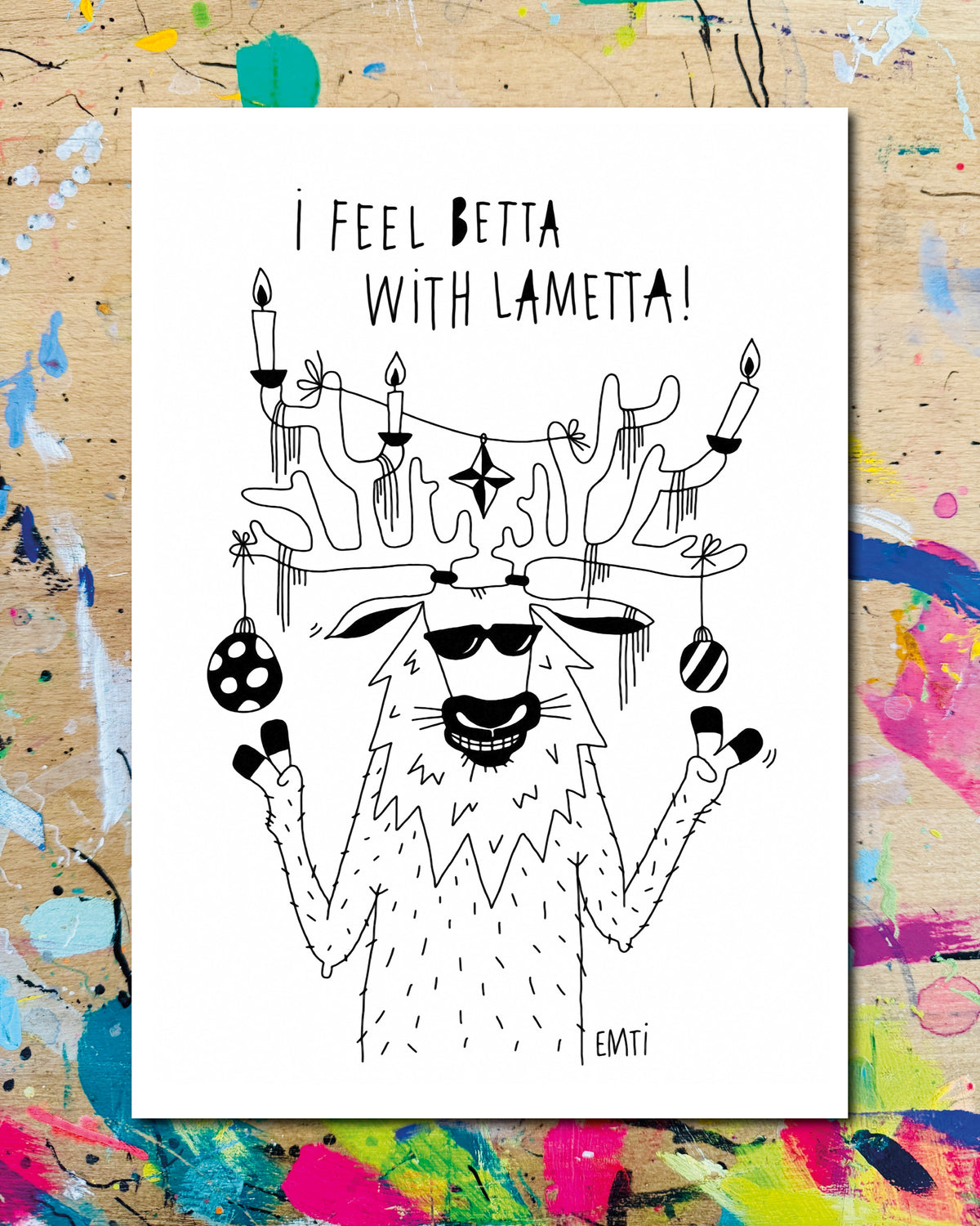 Postkarte: ein Hirsch mit Sonnenbrille, das Geweih mit Kerzen, Lametta und Christbaumkugeln geschmückt, dazu der Schriftzug „I feel betta with Lametta!“