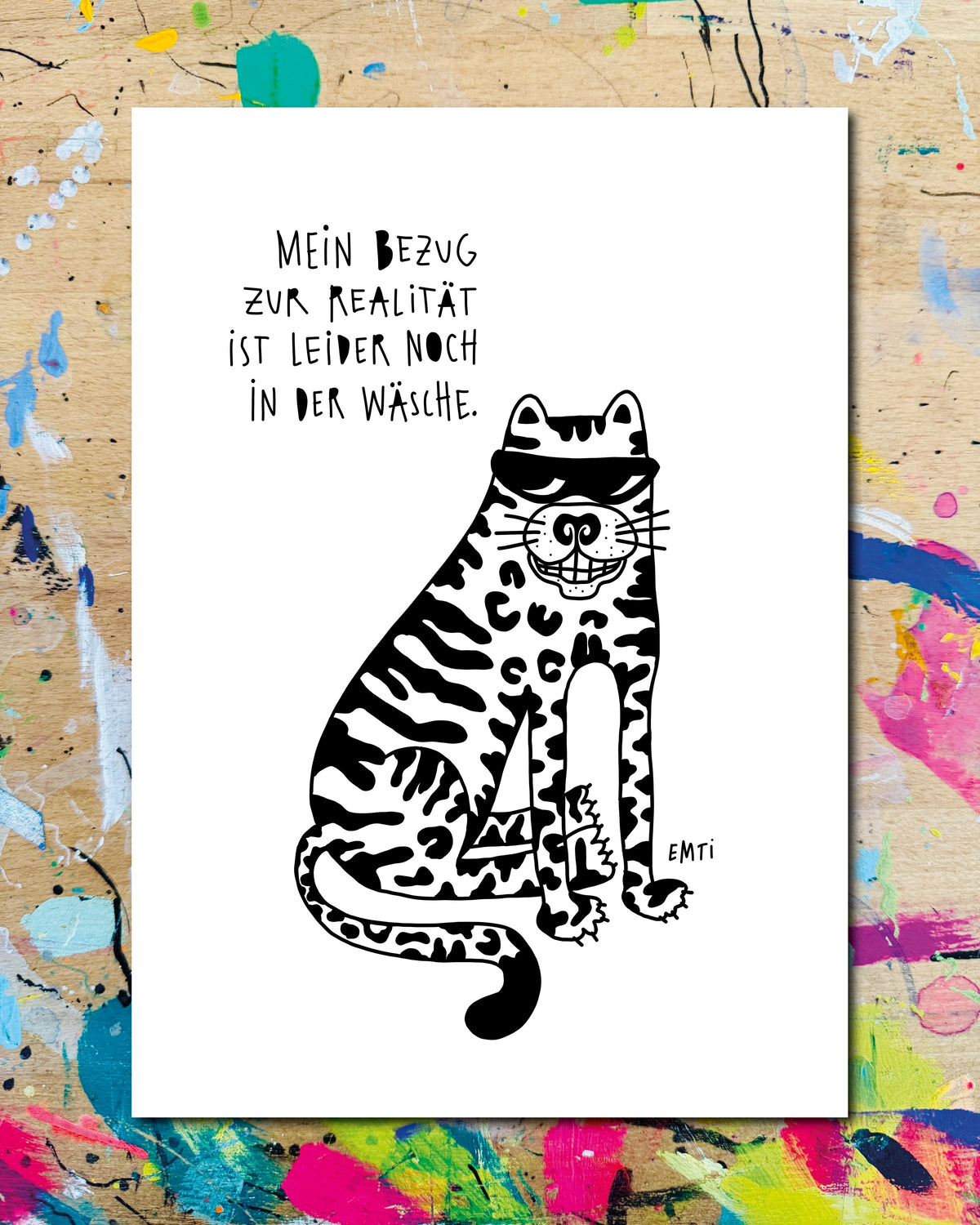 Postkarte: ein gemusterter Tiger mit Sonnenbrille, dazu der Schriftzug „Mein Bezug zur Realität ist leider noch in der Wäsche.“