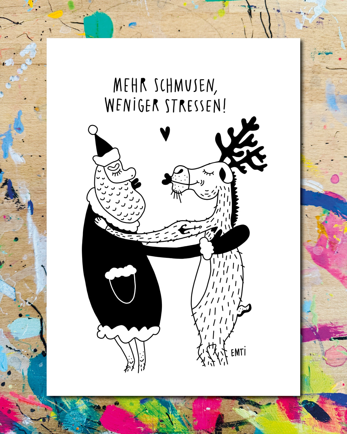 Postkarte: ein Weihnachtsmann und ein Rentier umarmen und küssen sich, über ihnen ein Herz, dazu der Schriftzug „Mehr schmusen, weniger stressen!“