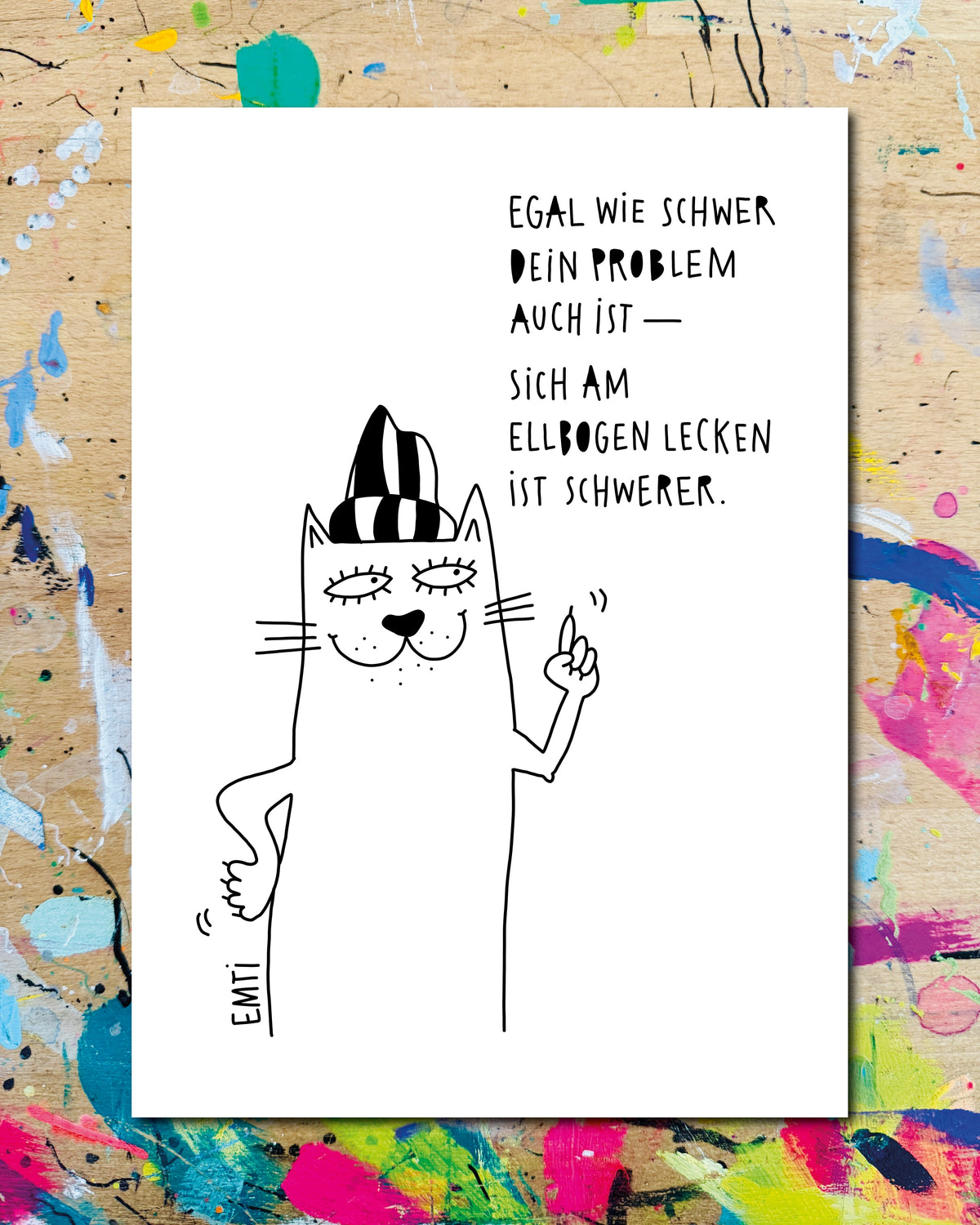 Postkarte: eine Katze mit Ringelmütze und erhobenem Zeigefinger, dazu der Schriftzug „Egal wie schwer dein Problem auch ist — sich am Ellbogen lecken ist schwerer.“