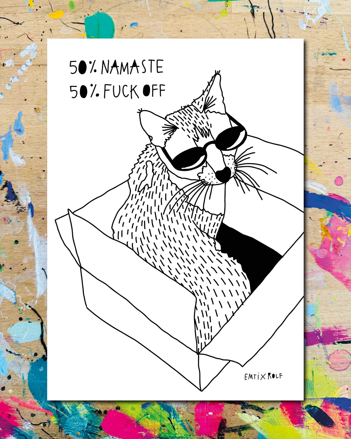 Postkarte: eine Katze mit Sonnenbrille sitzt in einem Karton, dazu der Schriftzug „50% Namaste, 50% Fuck off“