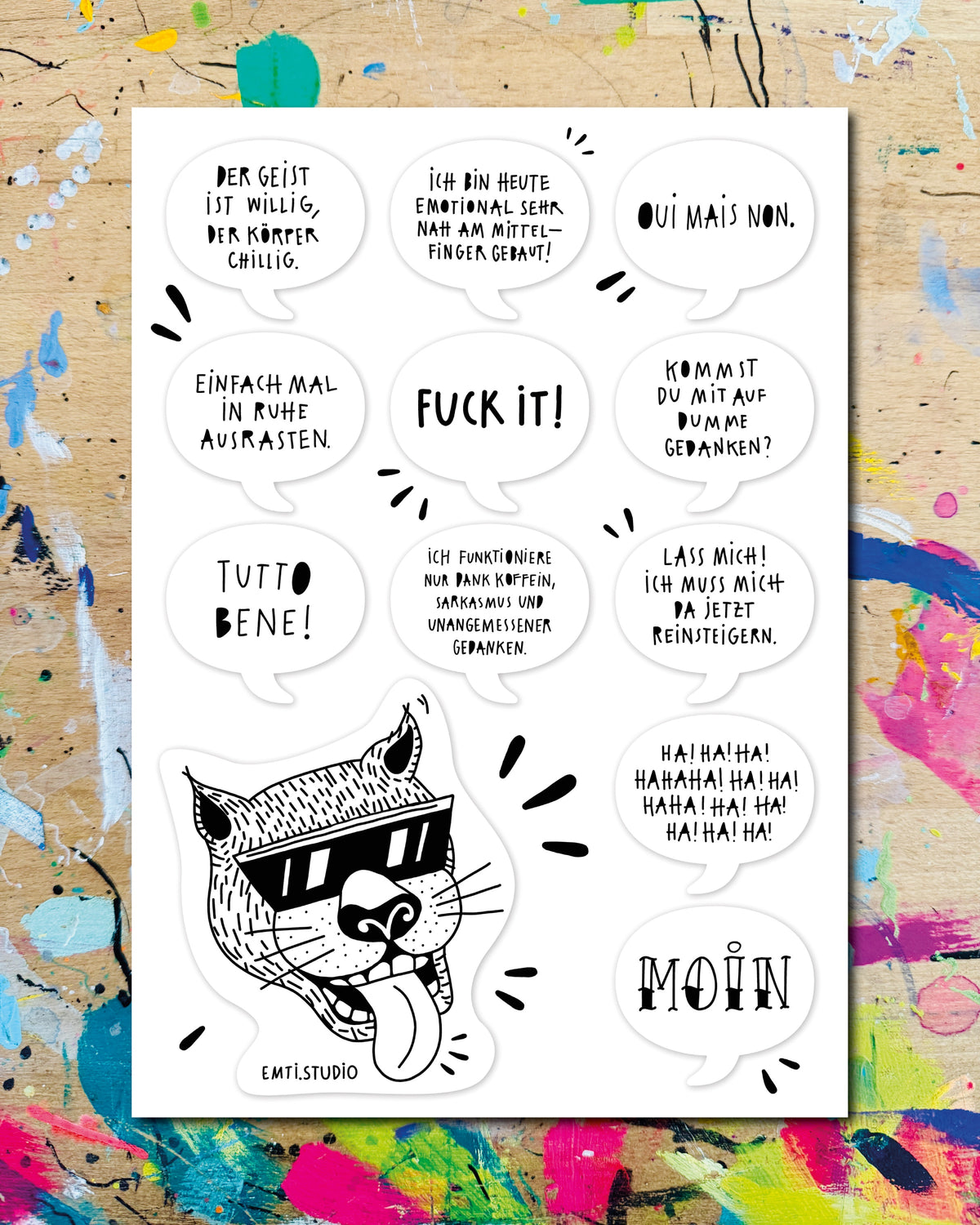 Stickerbogen mit Sprüchen und einem Katzenkopf mit Sonnenbrille und herausgestreckter Zunge, darunter „Fuck it!“, „Oui mais non.“ und „Moin“