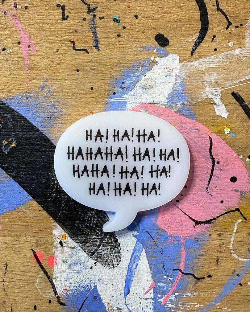 Sprechblase aus Acryl mit dem Schriftzug „Ha! Ha! Ha! Hahaha! Ha! Ha! Haha! Ha! Ha! Ha! Ha! Ha!“