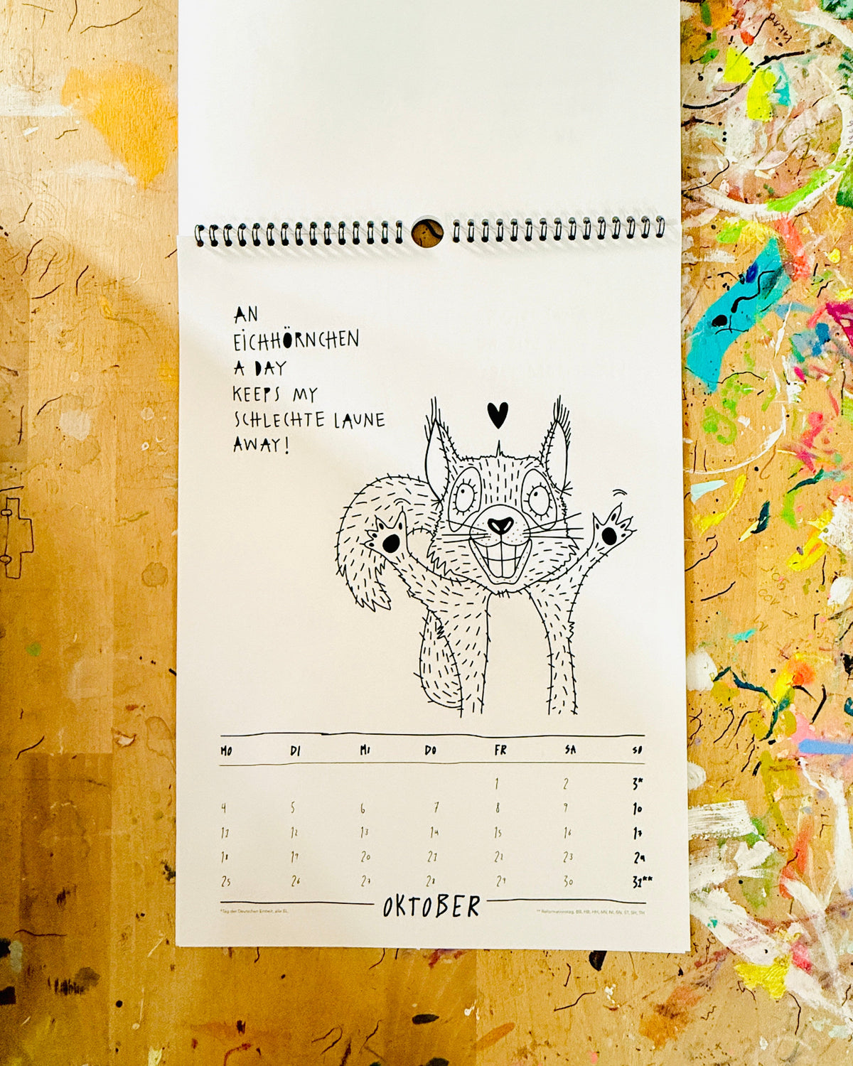 Kalenderblatt Oktober: ein Eichhörnchen breitet die Arme aus, dazu „An Eichhörnchen a day keeps my schlechte Laune away!“