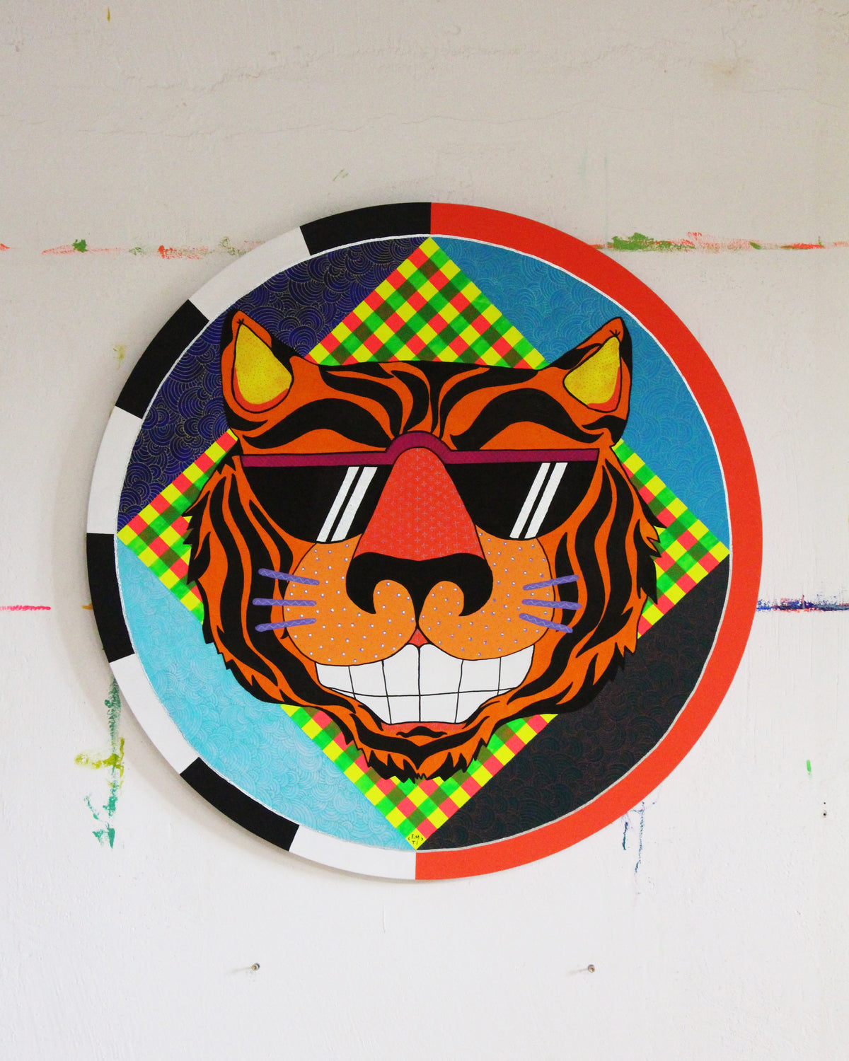 Rundes Bild: ein Tigerkopf mit Sonnenbrille auf kariertem Grund, gerahmt von einem roten und einem schwarzweissen Ring